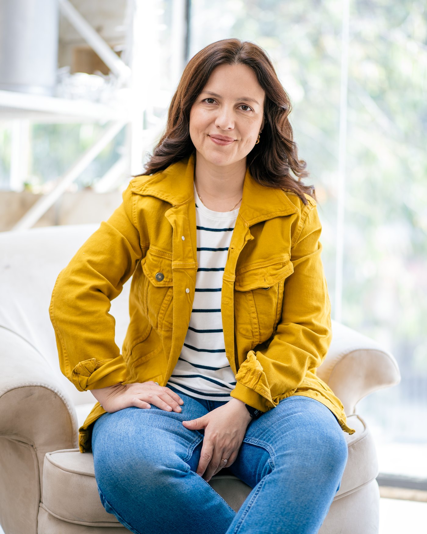 Tatiana Rodríguez Leal sitting in an armchair, wearing a yellow jacket